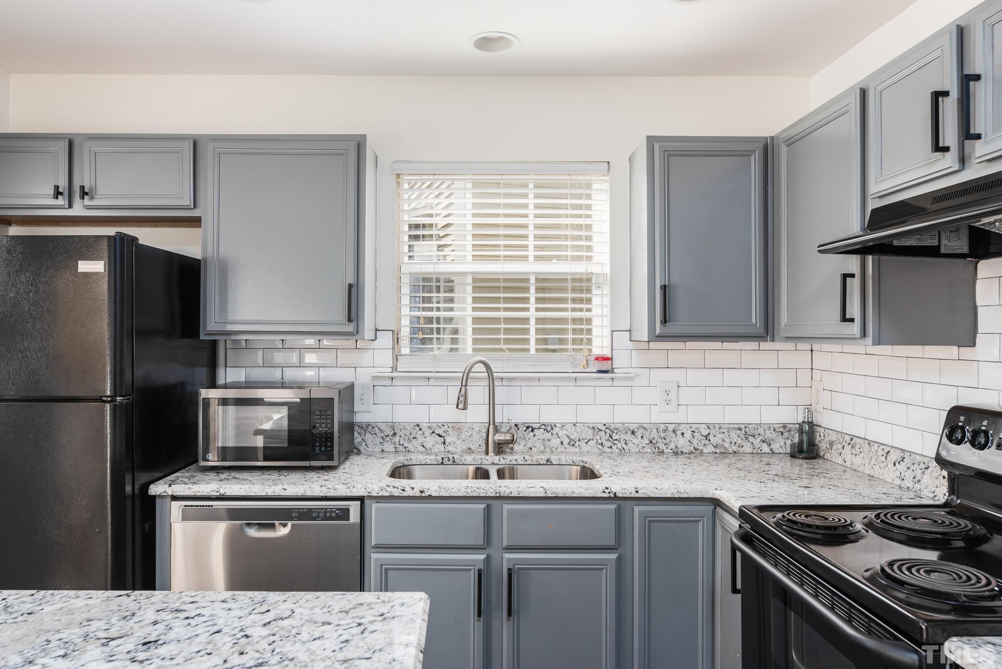 7814 Averette Field Drive Raleigh, NC 27616 - Photo 6 of 24 a kitchen with a sink stove and refrigerator