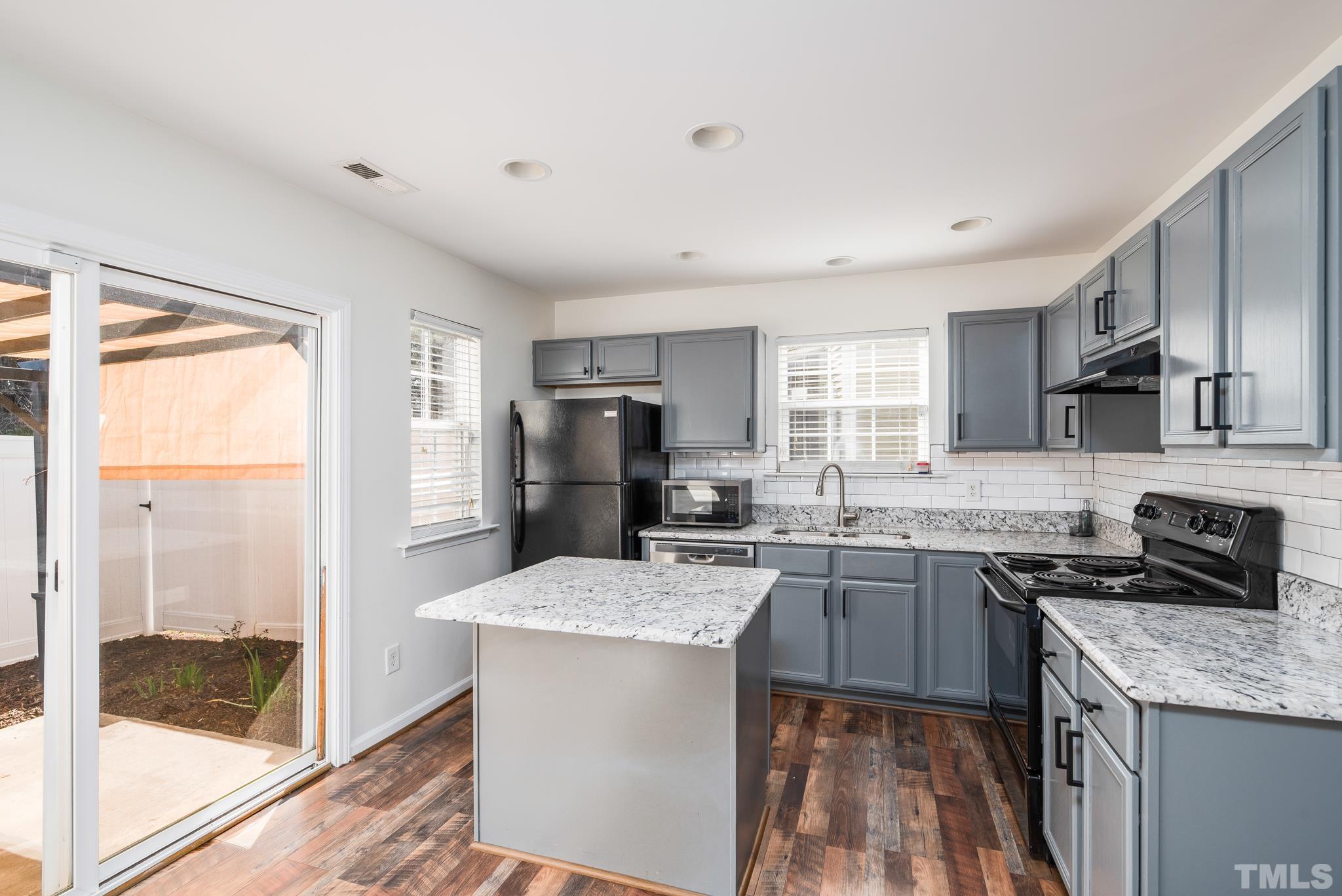 7814 Averette Field Drive Raleigh, NC 27616 - Photo 7 of 24 a kitchen with stainless steel appliances granite countertop a sink stove refrigerator and cabinets