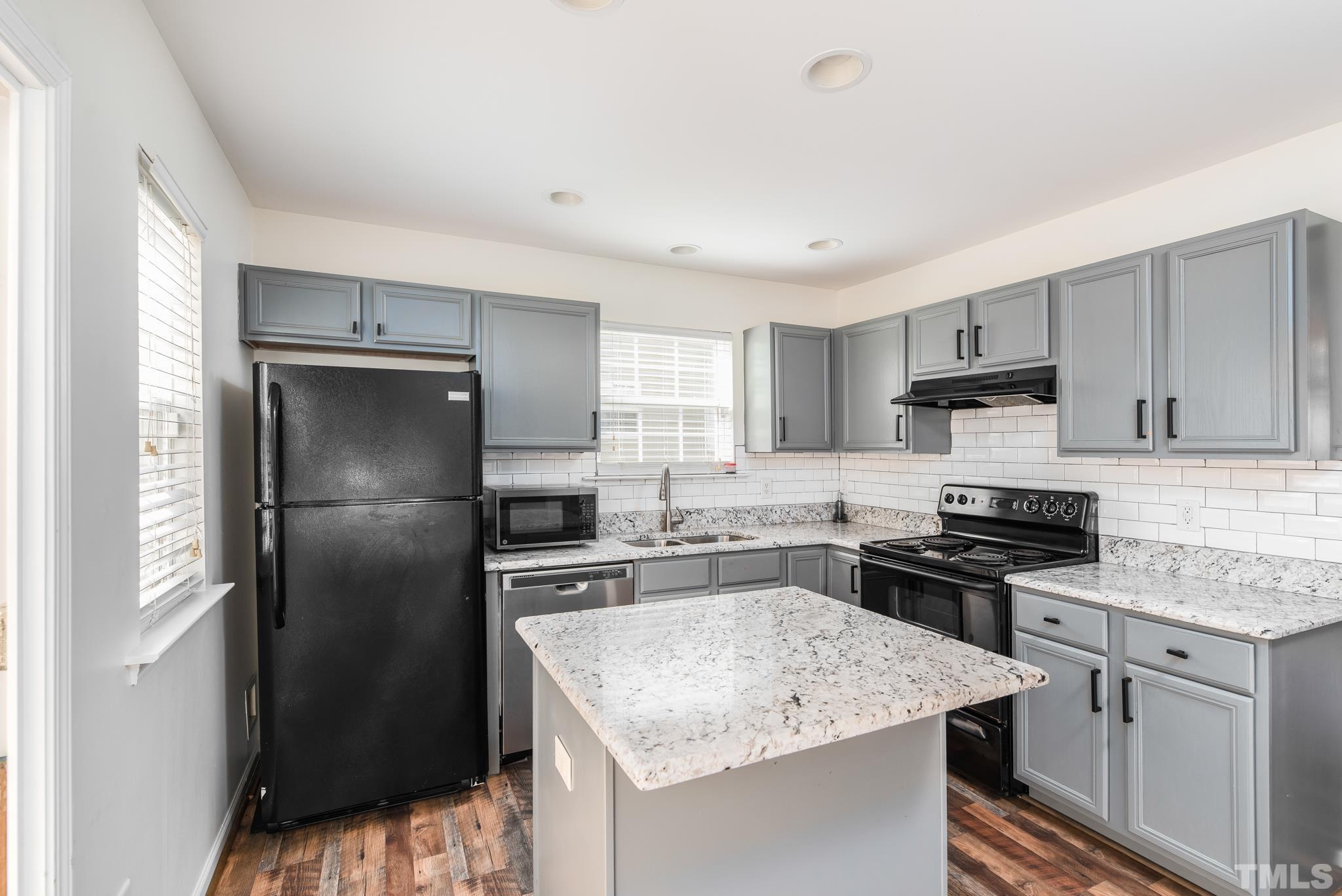 7814 Averette Field Drive Raleigh, NC 27616 - Photo 8 of 24 a kitchen with a granite countertop refrigerator a sink a stove a refrigerator and cabinets
