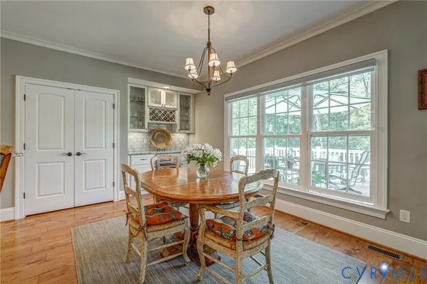 a dining room with furniture a chandelier and wooden floor