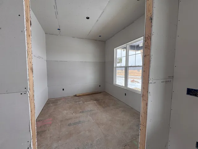 an empty room with closet and windows