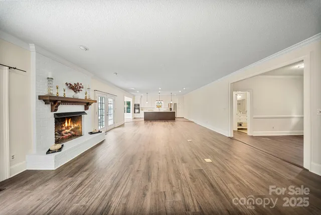 a view of empty room with a fireplace and wooden floor