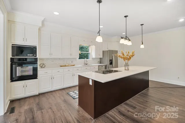 a kitchen with sink cabinets and wooden floor