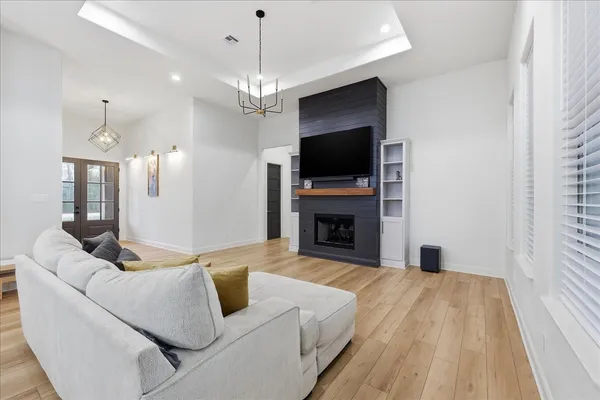a living room with furniture or chandelier and a wooden floor