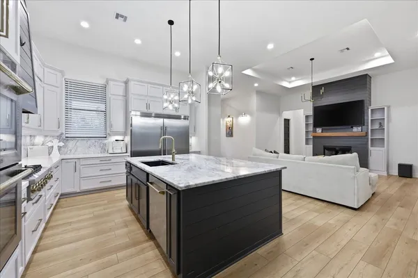 a kitchen with kitchen island granite countertop a sink counter top space appliances and cabinets