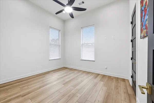 an empty room with a window and a ceiling fan