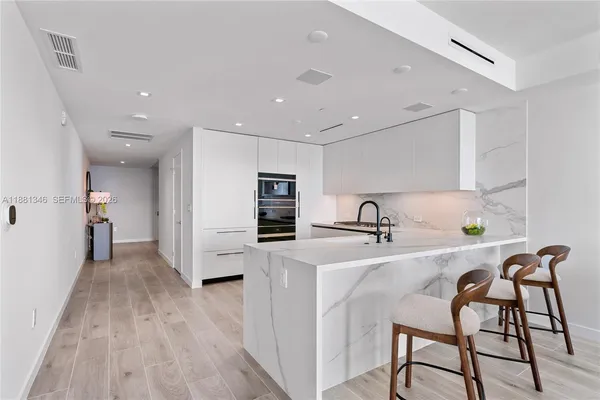 a kitchen with granite countertop a refrigerator stove and sink