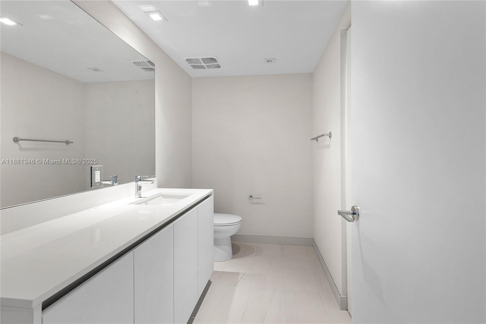 1116 North Ocean Boulevard, Unit 1404 Pompano Beach, FL 33062 - Photo 56 of 80 a bathroom with a sink a toilet and a mirror