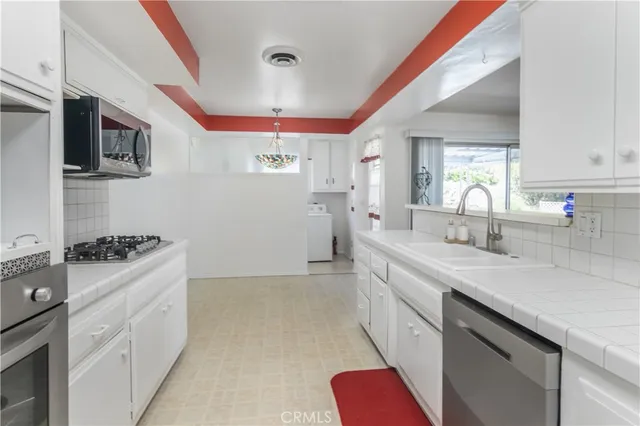 a kitchen with granite countertop a sink stainless steel appliances a counter space and a window