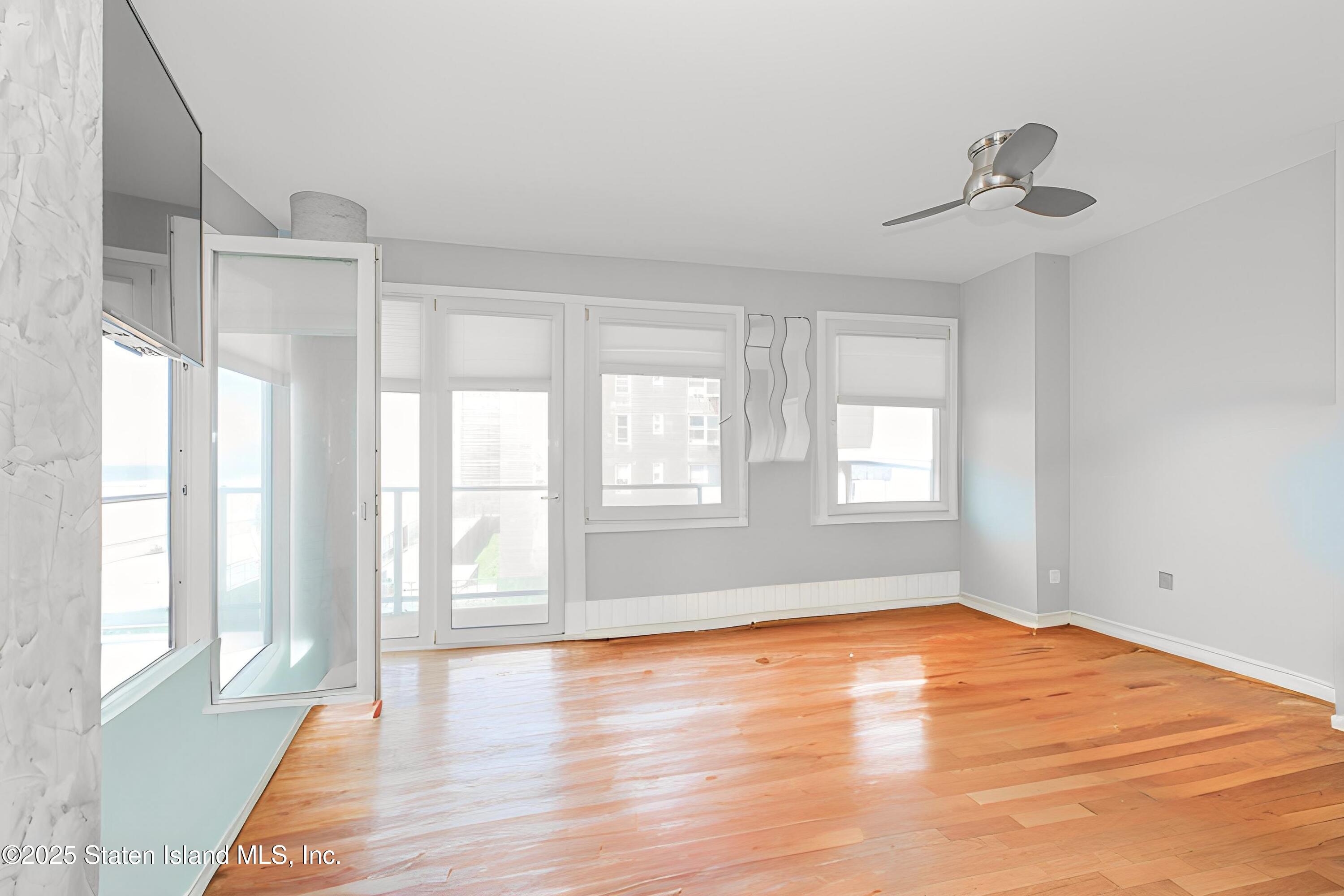 130 Beach 119th Street, Unit 3B Queens, NY 11694 - Photo 14 of 29 a view of empty room with wooden floor and fan