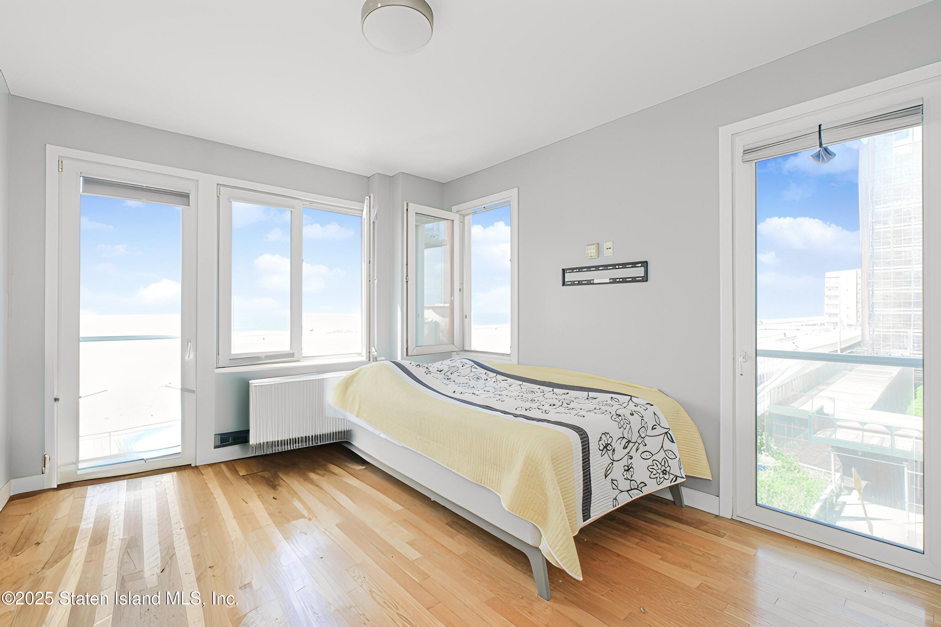 130 Beach 119th Street, Unit 3B Queens, NY 11694 - Photo 18 of 29 a bedroom with a bed and a large window