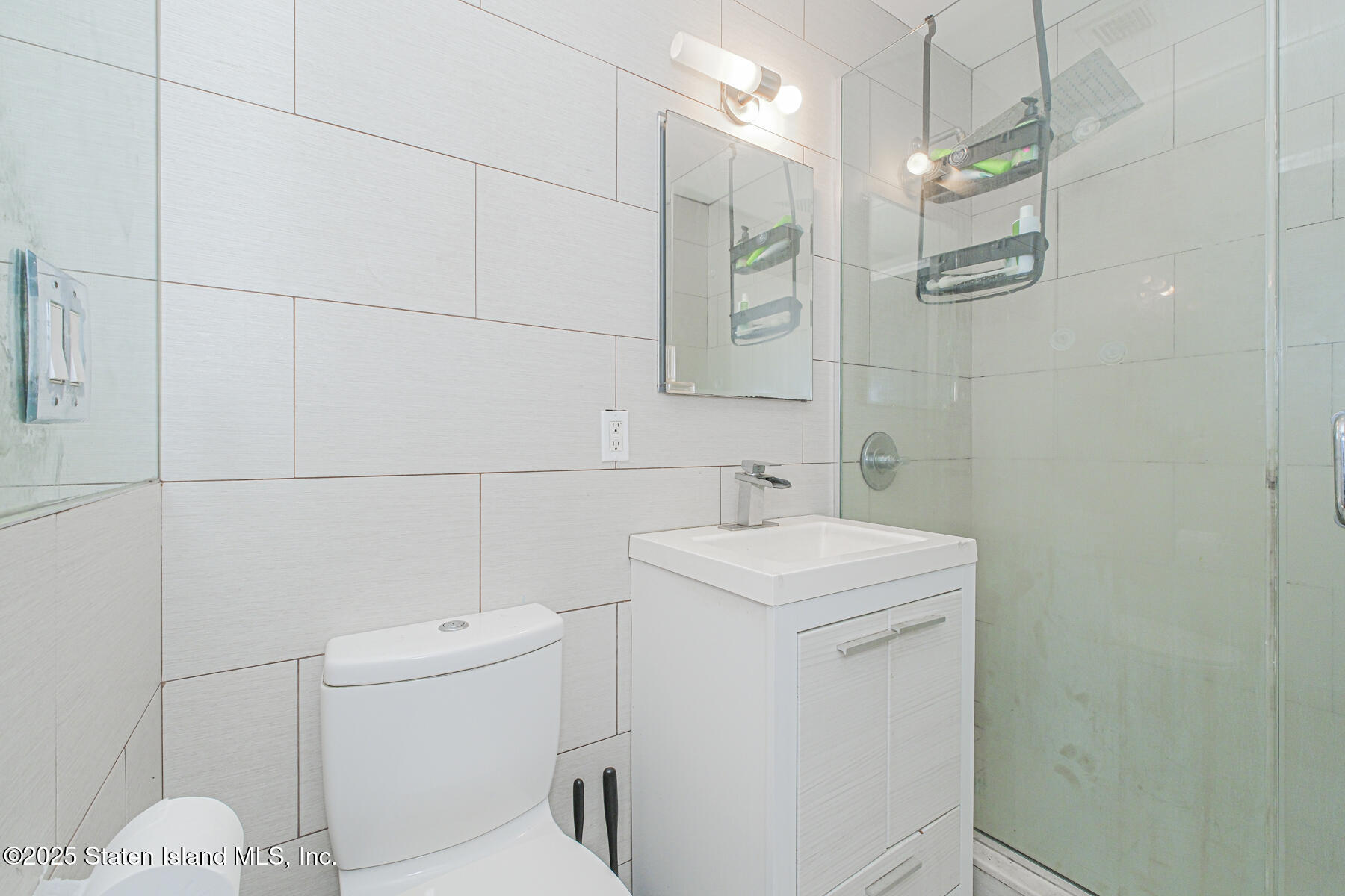 130 Beach 119th Street, Unit 3B Queens, NY 11694 - Photo 19 of 29 a bathroom with a toilet sink and mirror