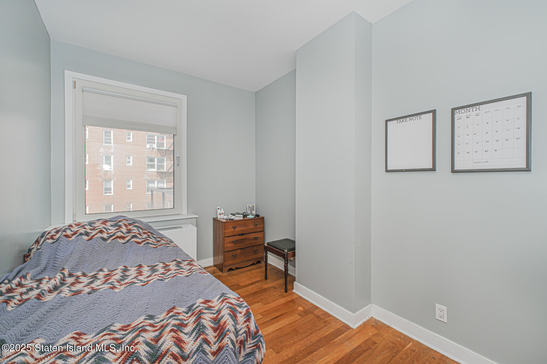 130 Beach 119th Street, Unit 3B Queens, NY 11694 - Photo 26 of 29 a bedroom with a bed and wooden floor