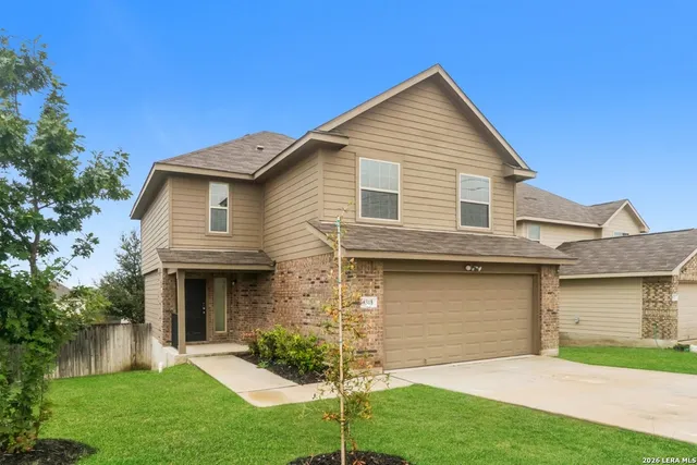 a front view of a house with a garden and yard