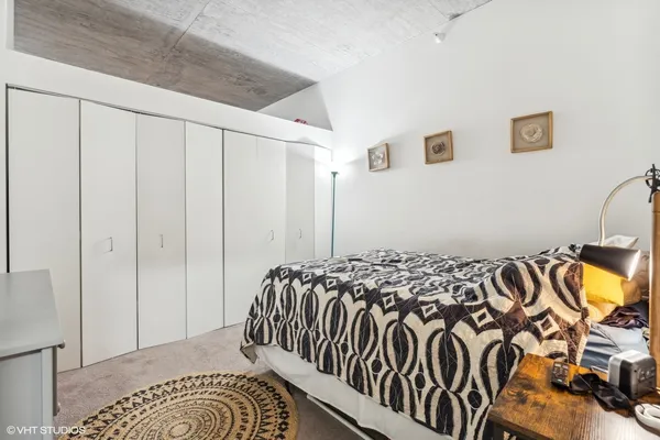 a bedroom with a bed and a painting on the wall
