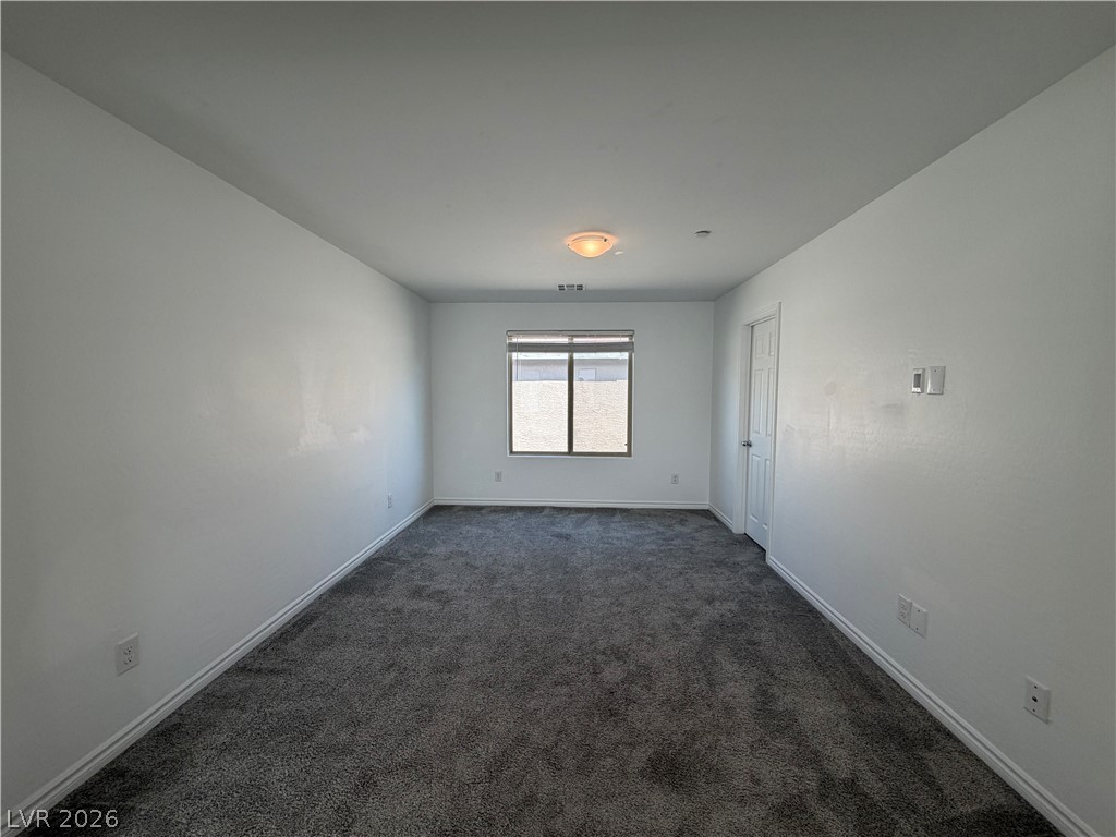 3228 Azalea Ridge Court Henderson, NV 89052 - Photo 17 of 28 A well-lit, neutral room with plush gray carpeting offers versatile living possibilities.