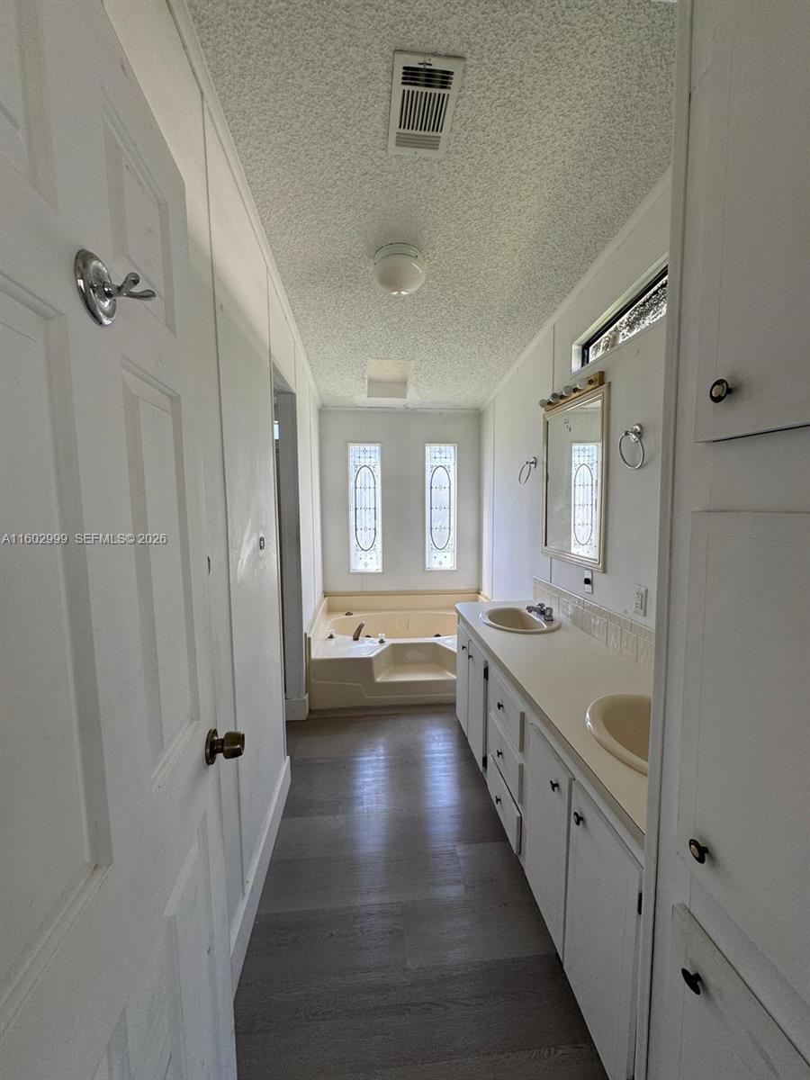 35250 Southwest 177th Court, Unit 136 Homestead, FL 33034 - Photo 13 of 23 a bathroom with a granite countertop sink a toilet a mirror and shower