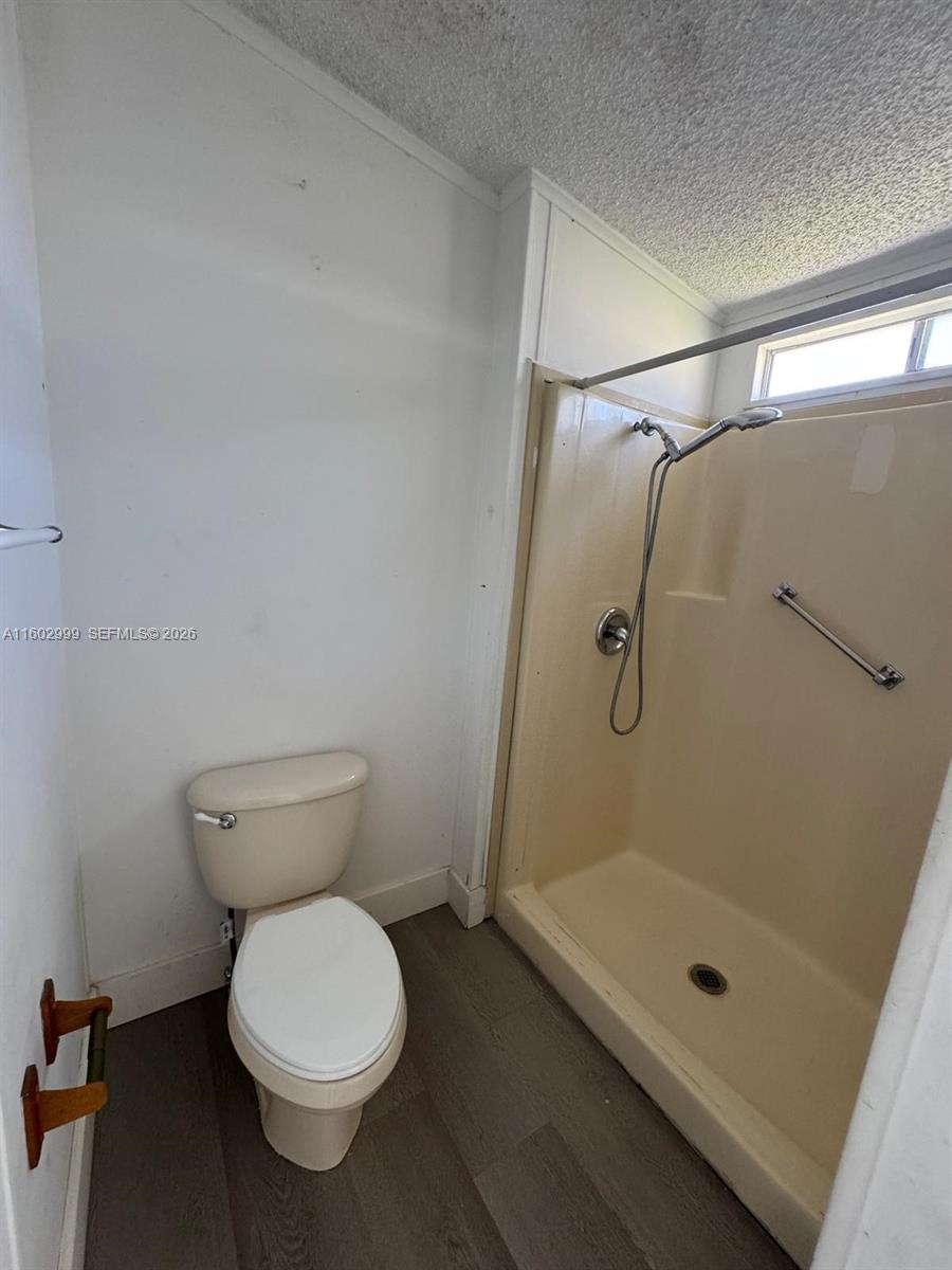 35250 Southwest 177th Court, Unit 136 Homestead, FL 33034 - Photo 16 of 23 a bathroom with a granite countertop toilet a sink and shower