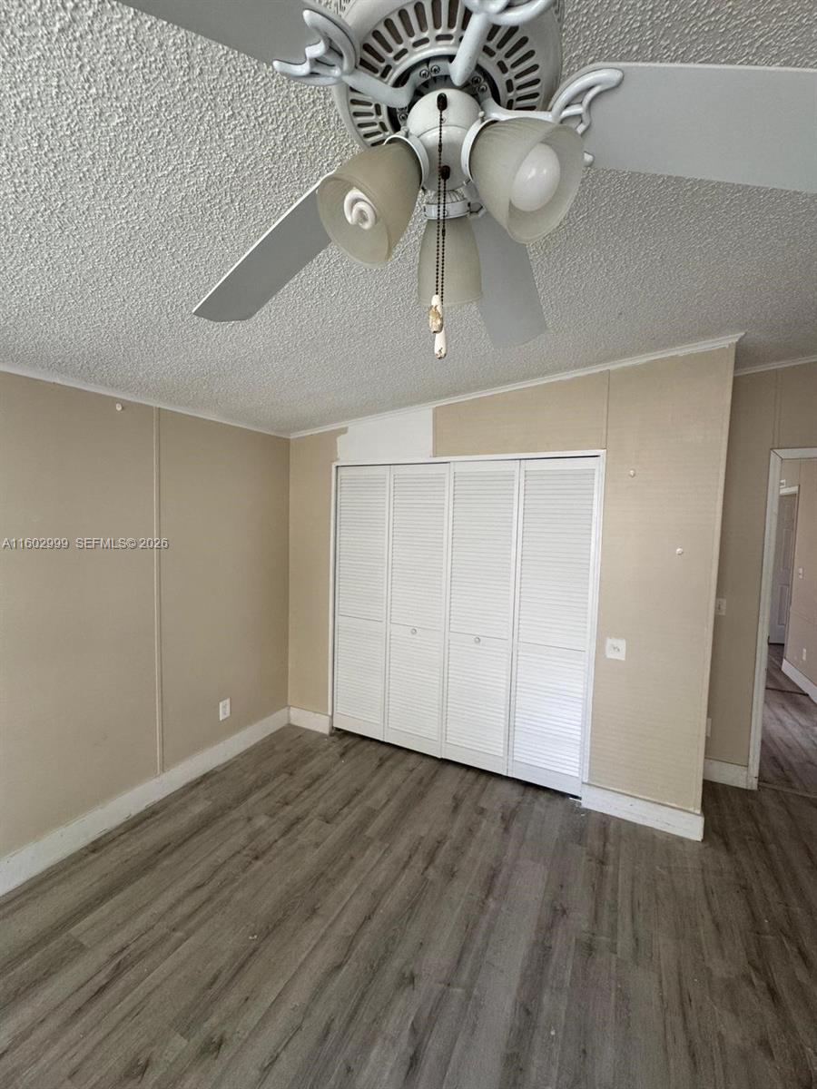 35250 Southwest 177th Court, Unit 136 Homestead, FL 33034 - Photo 17 of 23 wooden floor in an empty room with a chandelier