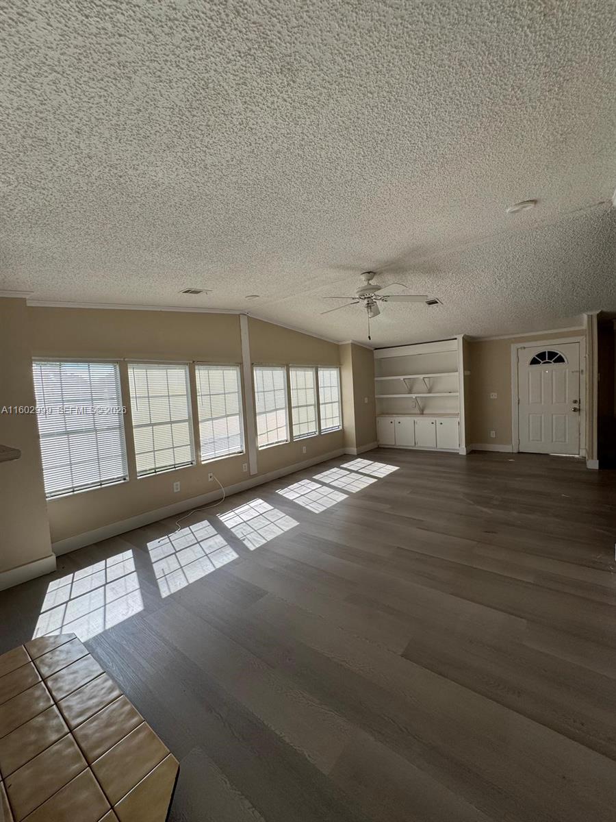 35250 Southwest 177th Court, Unit 136 Homestead, FL 33034 - Photo 21 of 23 a view of empty room with wooden floor and fan