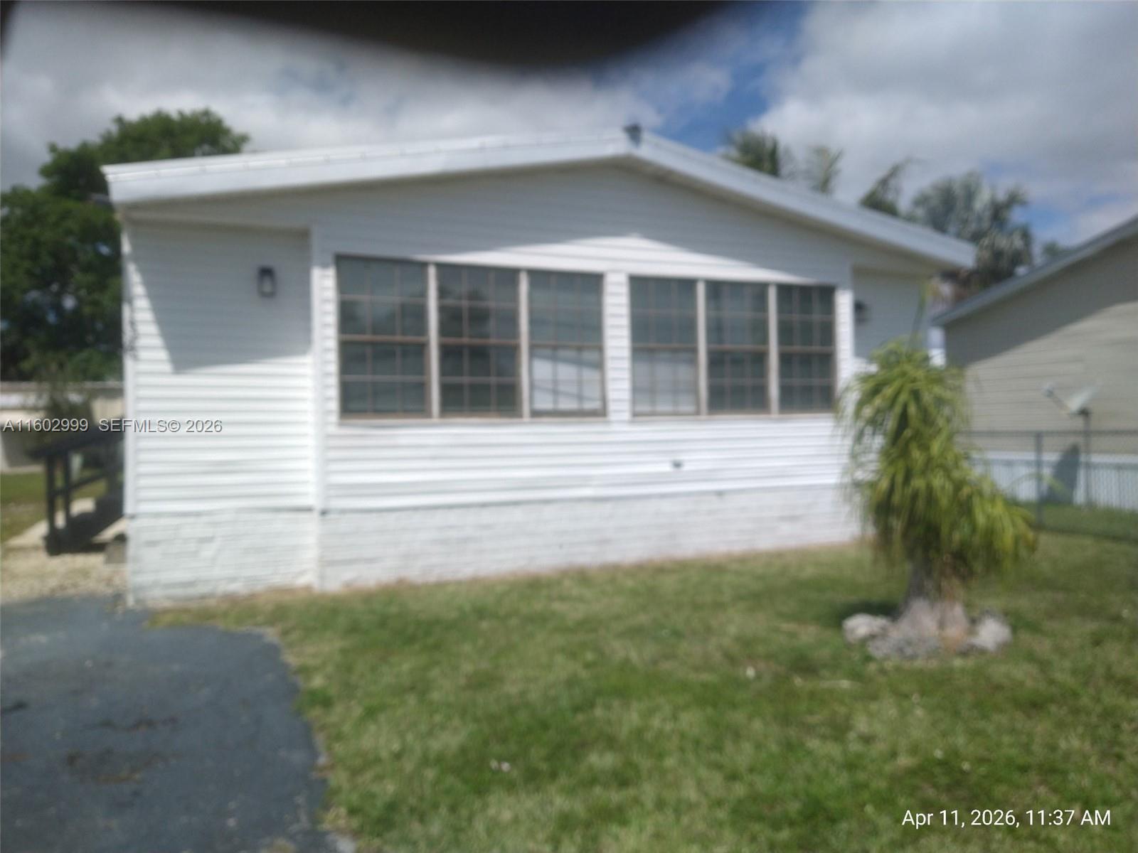35250 Southwest 177th Court, Unit 136 Homestead, FL 33034 - Photo 3 of 23 a front view of a house with a yard