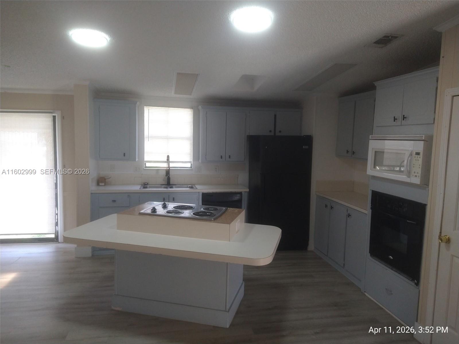 35250 Southwest 177th Court, Unit 136 Homestead, FL 33034 - Photo 6 of 23 a kitchen with a refrigerator and a stove top oven