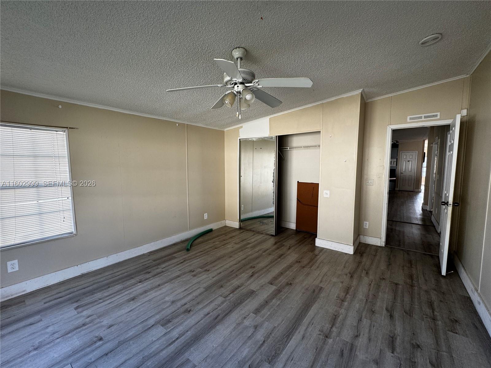 35250 Southwest 177th Court, Unit 136 Homestead, FL 33034 - Photo 9 of 23 wooden floor in an empty room with a window