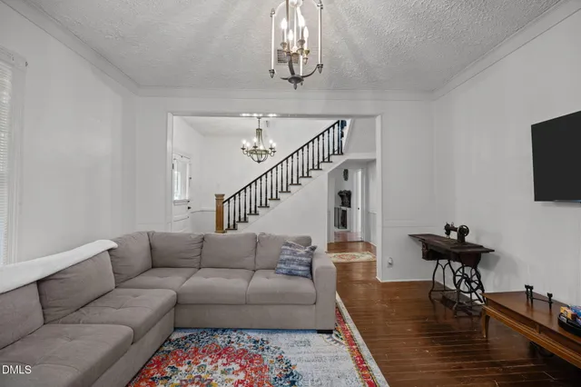 a living room with furniture and a flat screen tv with kitchen view