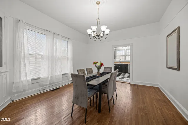 a view of a dining room with furniture a chandelier and wooden floor