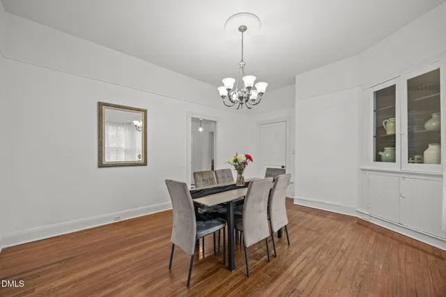 a view of a dining room with furniture a chandelier and wooden floor