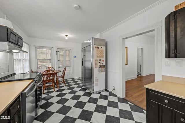 a kitchen with a checkered floor and black appliances