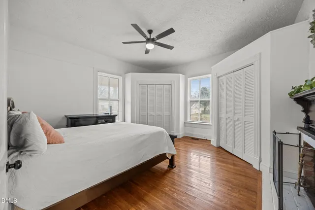 a bedroom with a bed and wooden floor