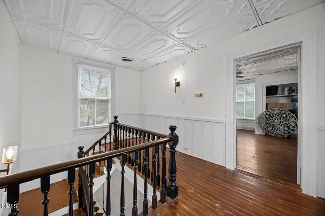 a view of a hallway with wooden floor and stairs