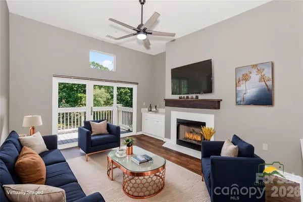 a living room with furniture a fireplace and a flat screen tv