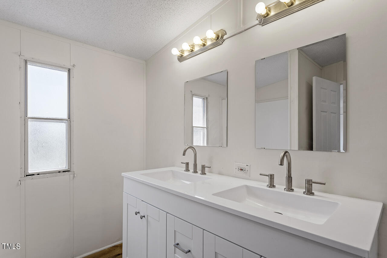 10335 West Old Spring Hope Road Spring Hope, NC 27882 - Photo 17 of 20 a bathroom with a double vanity sink and a mirror