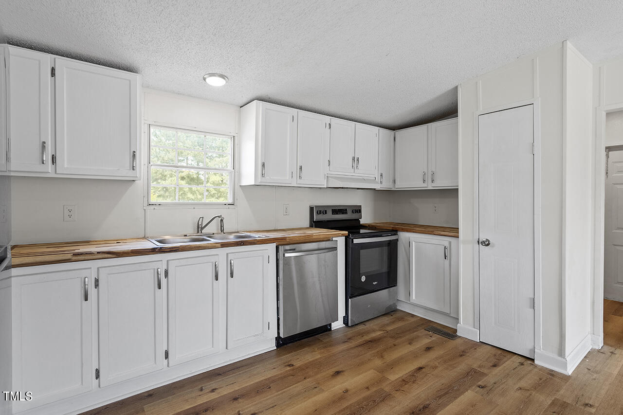 10335 West Old Spring Hope Road Spring Hope, NC 27882 - Photo 6 of 20 a kitchen with granite countertop white cabinets and stainless steel appliances