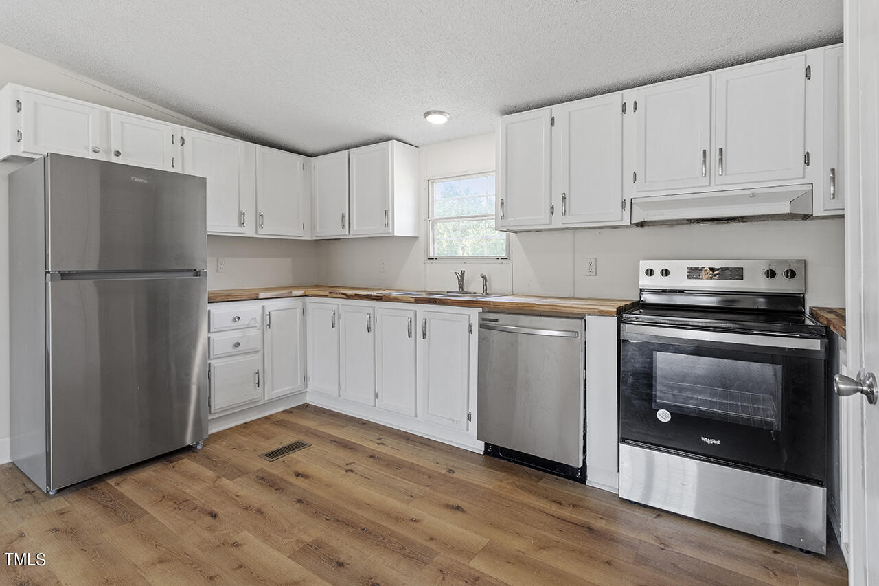 10335 West Old Spring Hope Road Spring Hope, NC 27882 - Photo 7 of 20 a kitchen with a refrigerator sink and cabinets