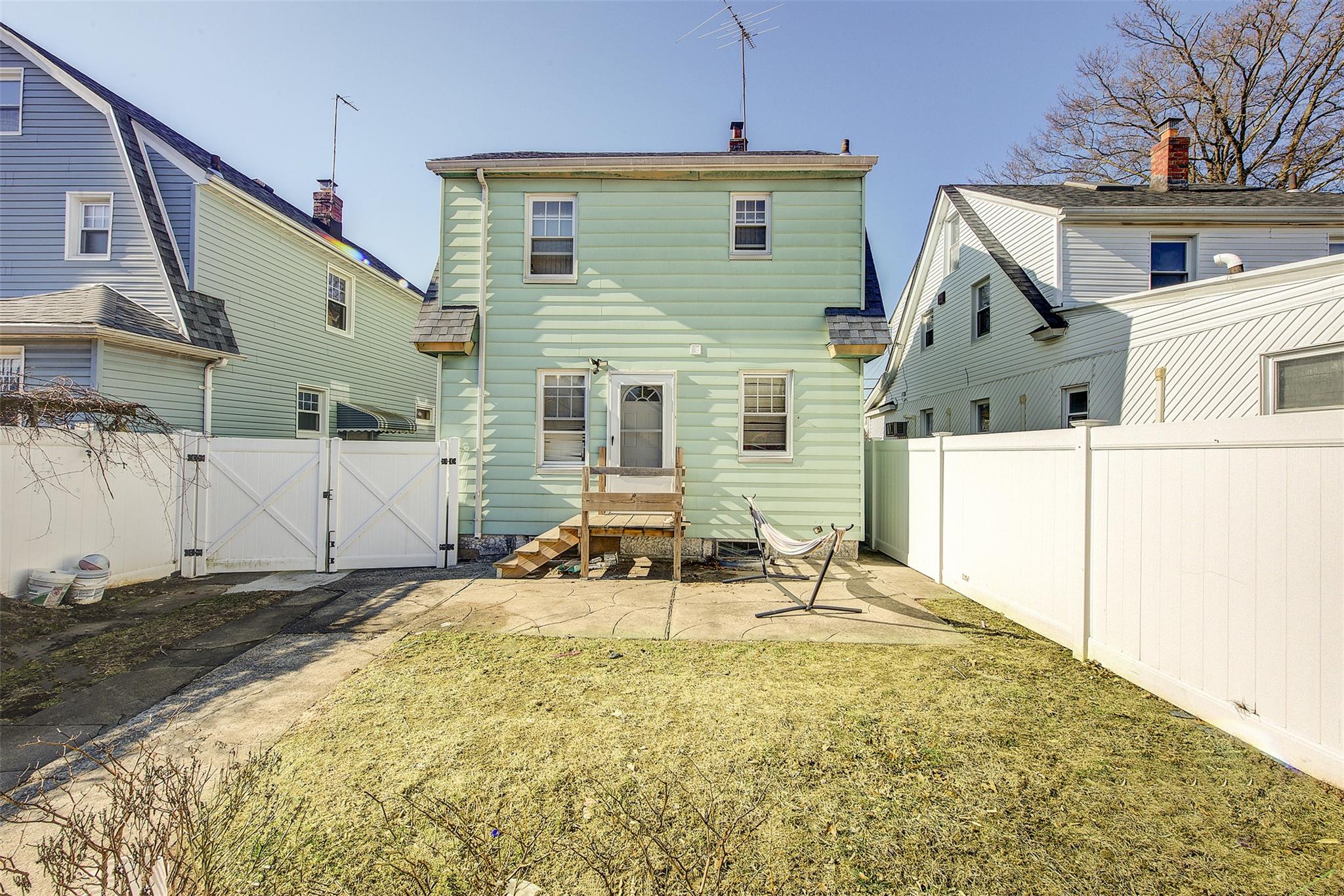 89-91 215th Place Queens, NY 11427 - Photo 4 of 16 Rear view of property with a patio area, a fenced backyard, a gate, and a yard