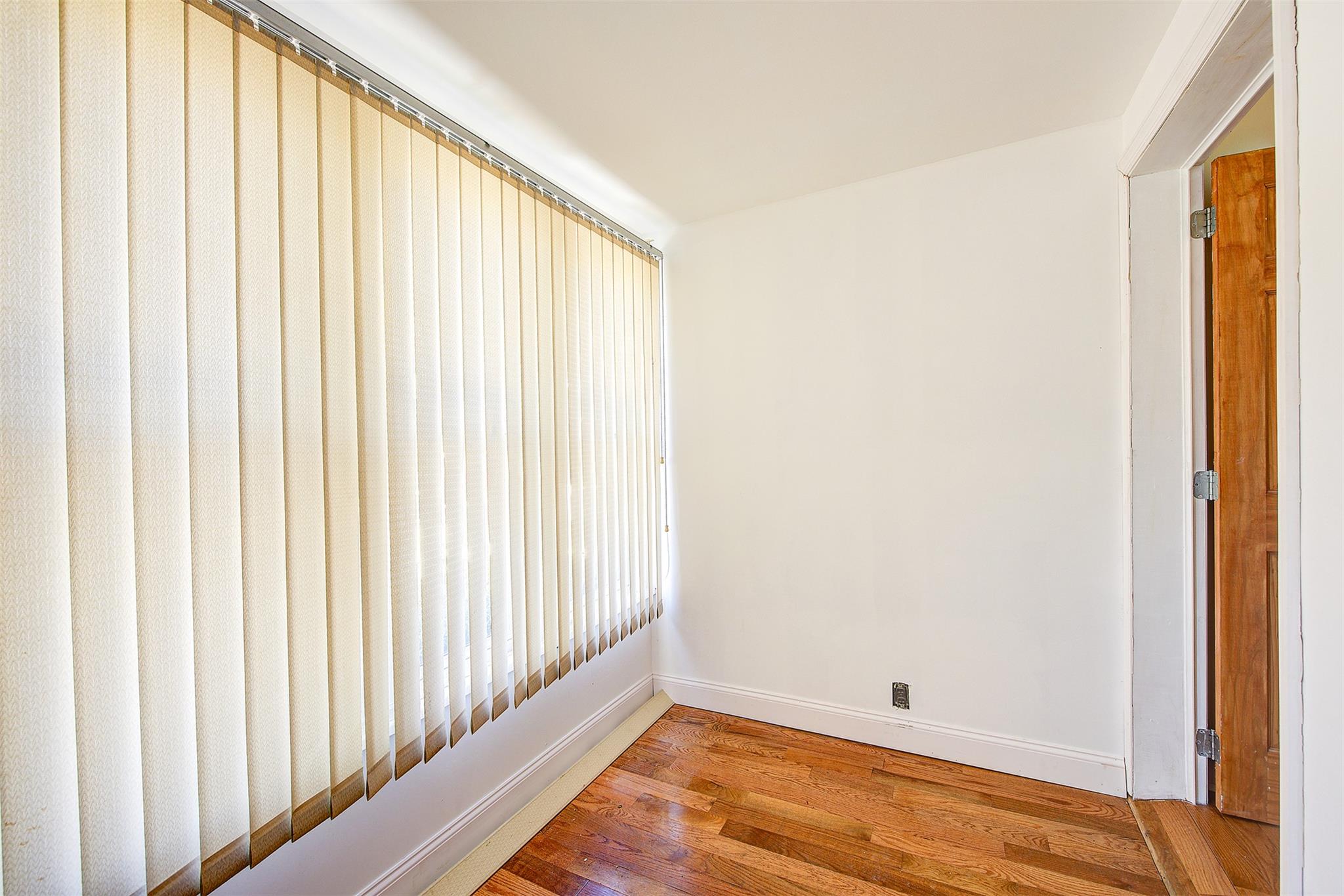89-91 215th Place Queens, NY 11427 - Photo 9 of 16 Spare room with baseboards and wood finished floors