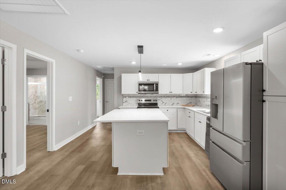 509 Sparella Street Durham, NC 27703 - Photo 14 of 30 a kitchen with white cabinets and stainless steel appliances