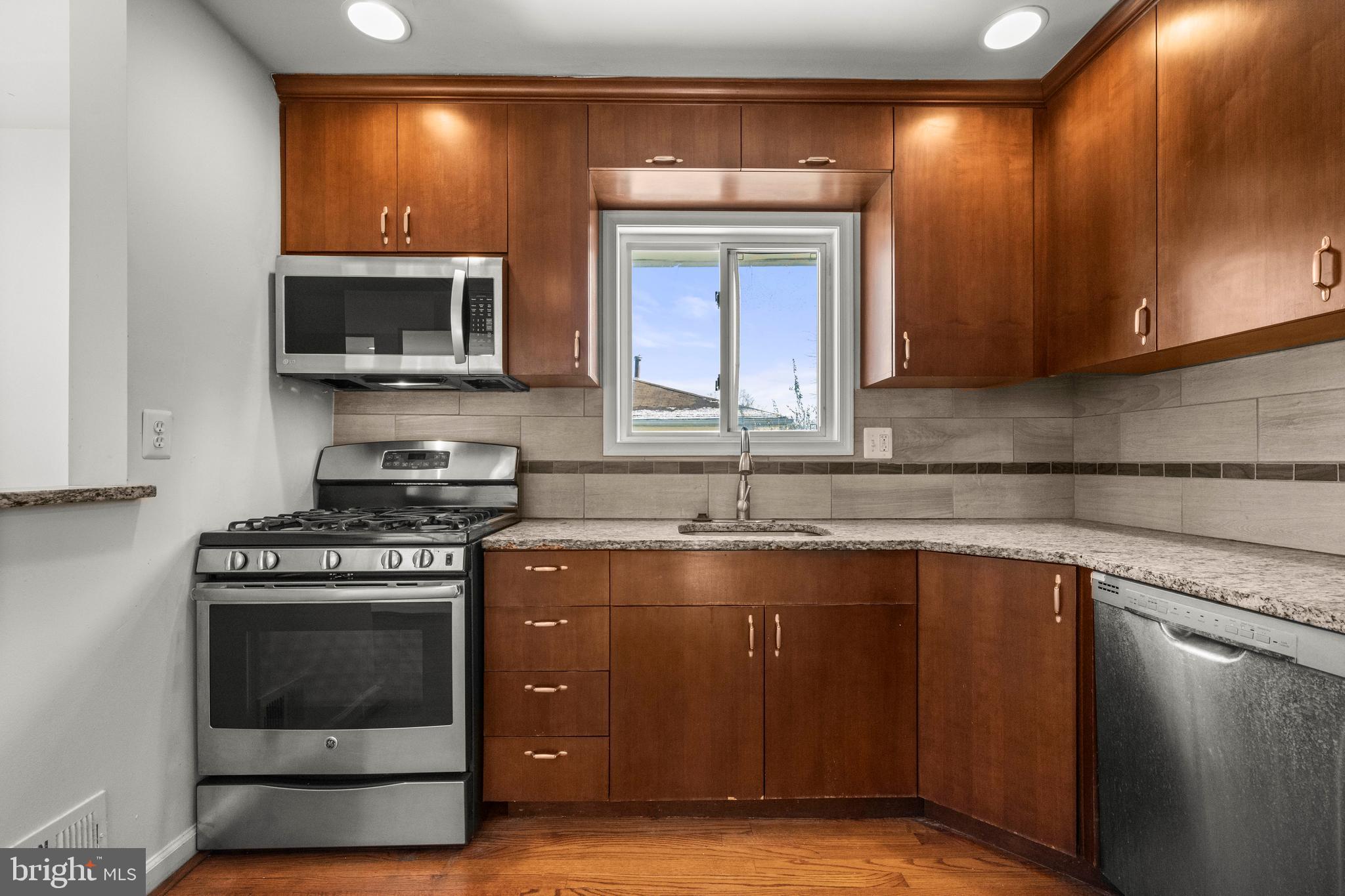 8100 Oxon Hill Road Fort Washington, MD 20744 - Photo 11 of 40 a kitchen with stainless steel appliances granite countertop a stove a sink and a microwave