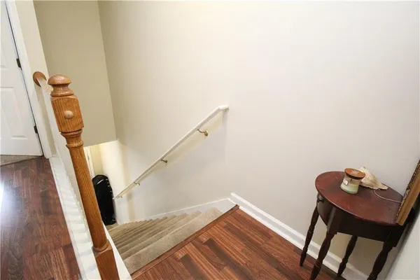 a view of a hallway with wooden floor and stairs