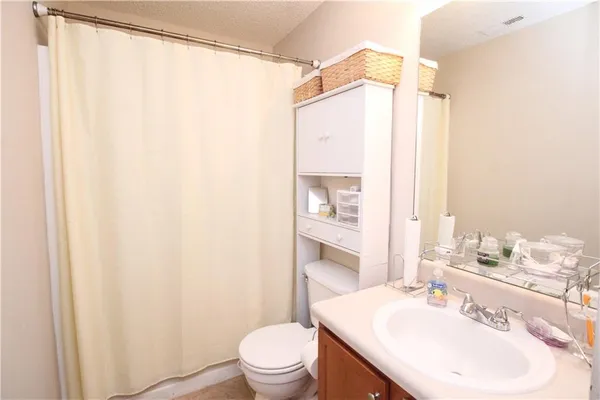 a bathroom with a sink mirror vanity and toilet