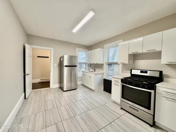 a kitchen with granite countertop a stove top oven and refrigerator