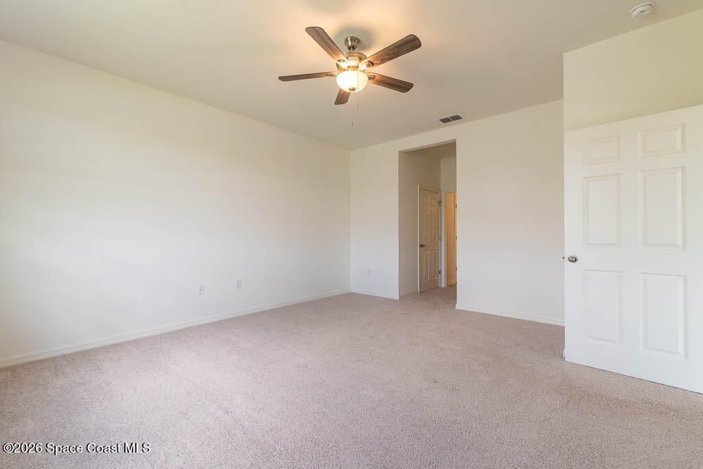 1863 Farmhouse Road Southeast Palm Bay, FL 32909 - Photo 11 of 44 an empty room with closet and a ceiling fan