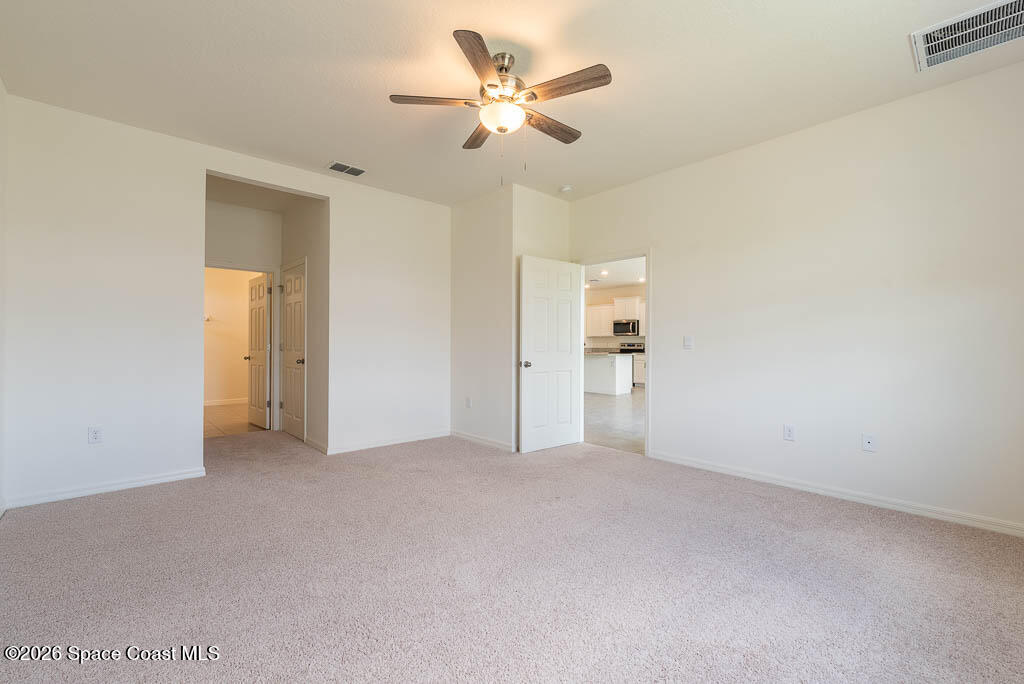 1863 Farmhouse Road Southeast Palm Bay, FL 32909 - Photo 12 of 44 a view of an empty room with a ceiling fan