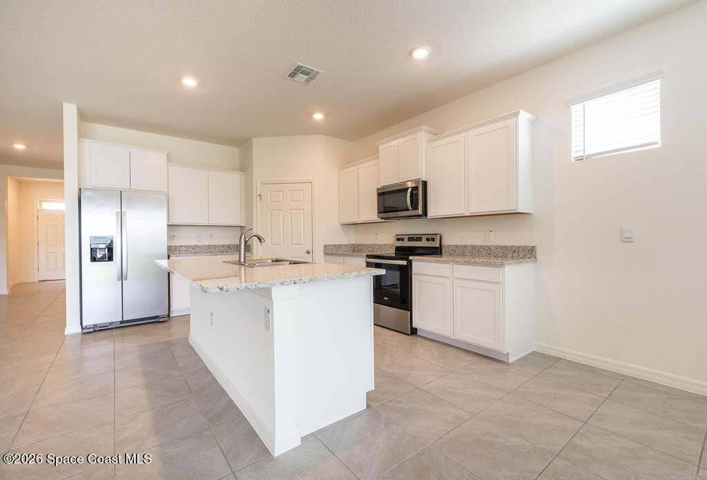 1863 Farmhouse Road Southeast Palm Bay, FL 32909 - Photo 19 of 44 a kitchen with sink a microwave and refrigerator