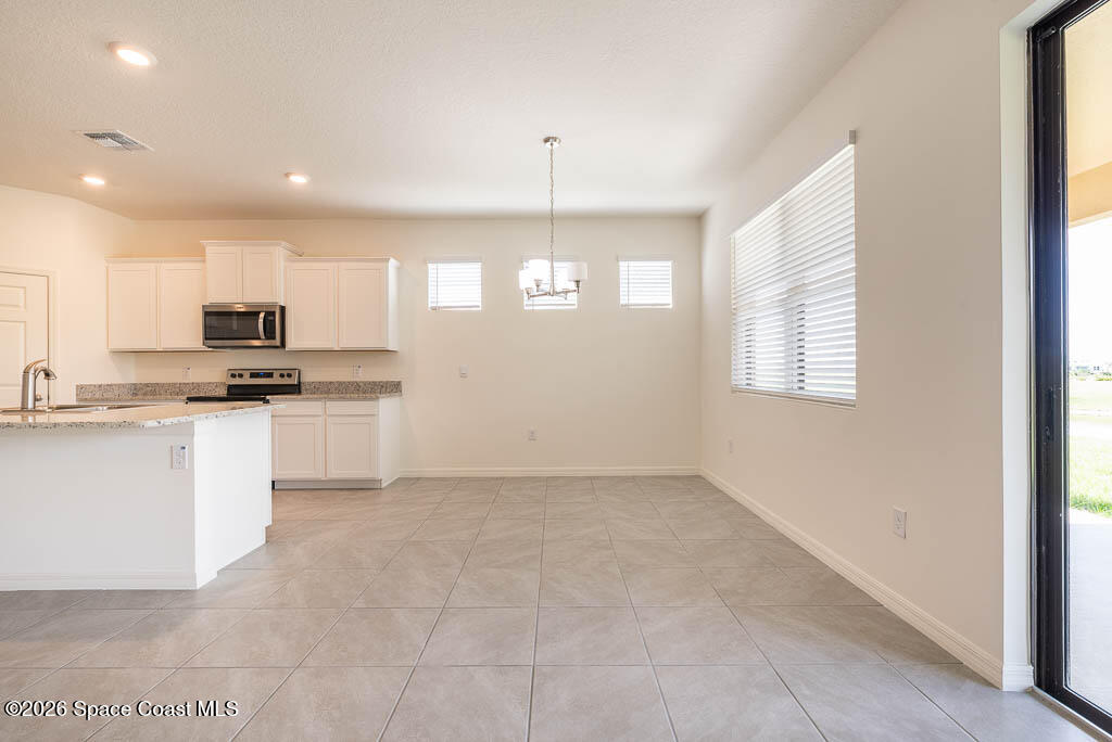 1863 Farmhouse Road Southeast Palm Bay, FL 32909 - Photo 20 of 44 a kitchen that has a lot of white cabinets and stainless steel appliances