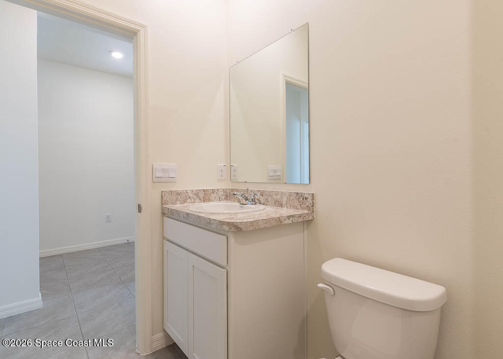1863 Farmhouse Road Southeast Palm Bay, FL 32909 - Photo 27 of 44 a bathroom with a sink a toilet and mirror
