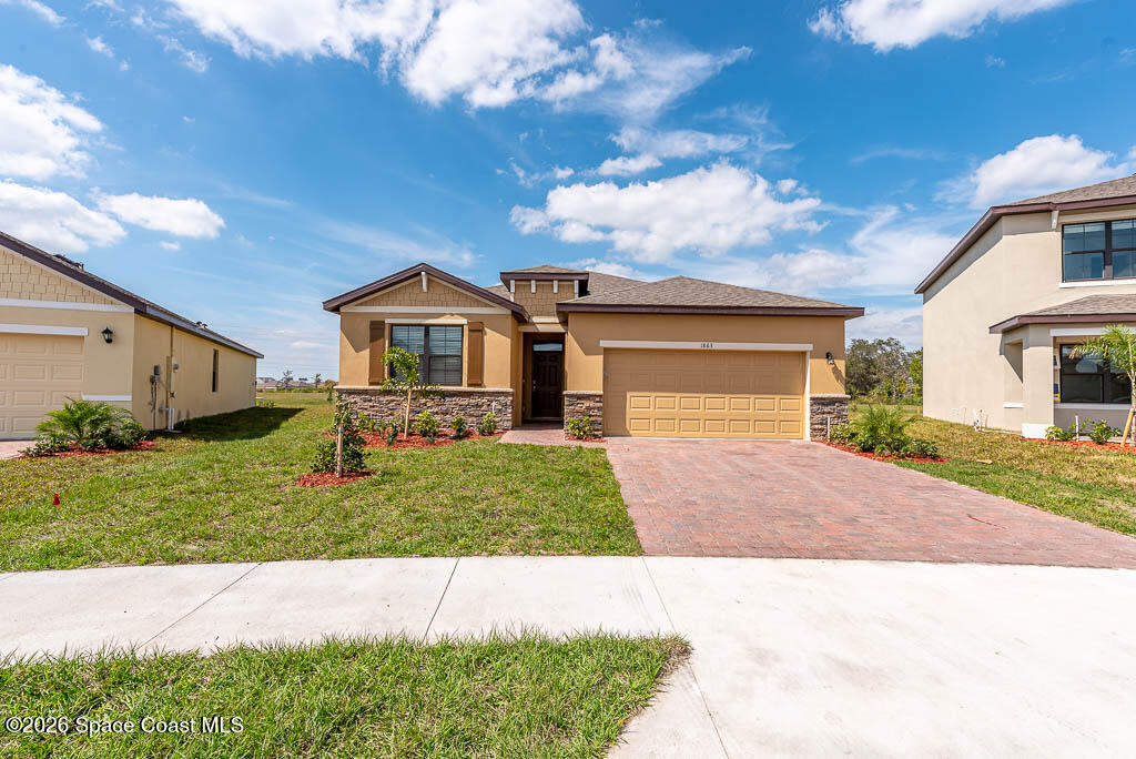 1863 Farmhouse Road Southeast Palm Bay, FL 32909 - Photo 5 of 44 a front view of a house with a yard and garage
